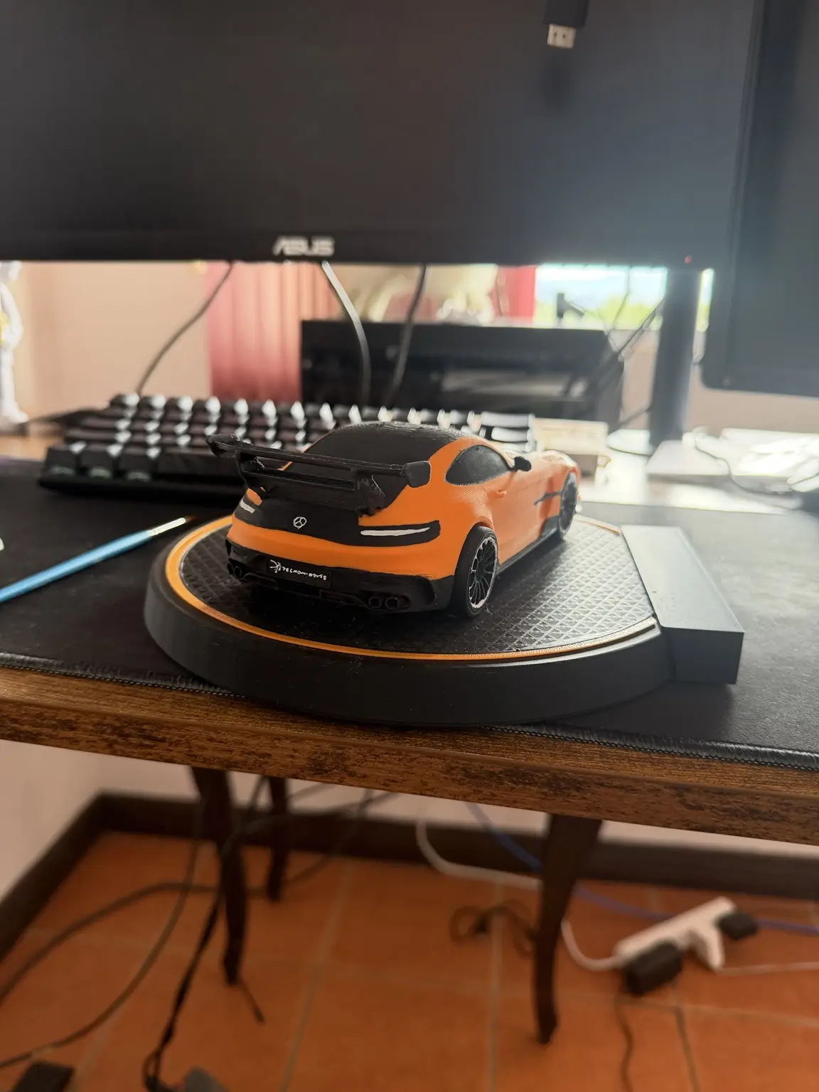 Vista trasera del modelo decorativo naranja terminado sobre su base